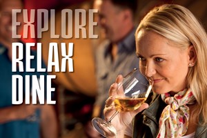 A lady with long blonde hair and a floral scarf around her neck sniffs a white wine at a wine tasting session in the Granite Belt. www.wellcamp.com.au
